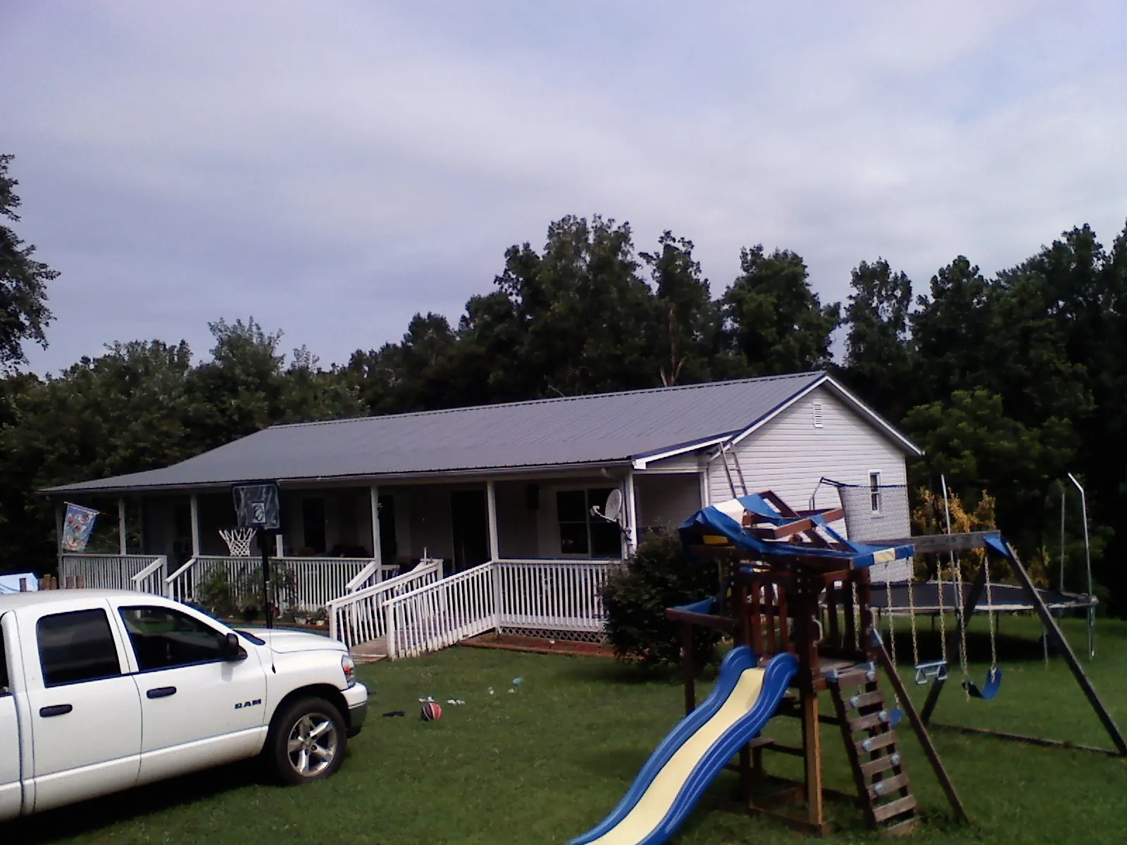 Dark metal roof on a country home with a full length front porch in Russell